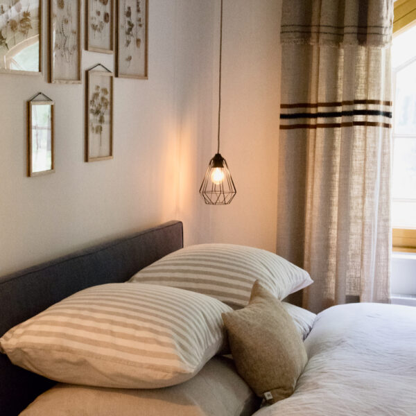 Slaapkamer met zicht op de tuin en leuke schilderijen boven het bed