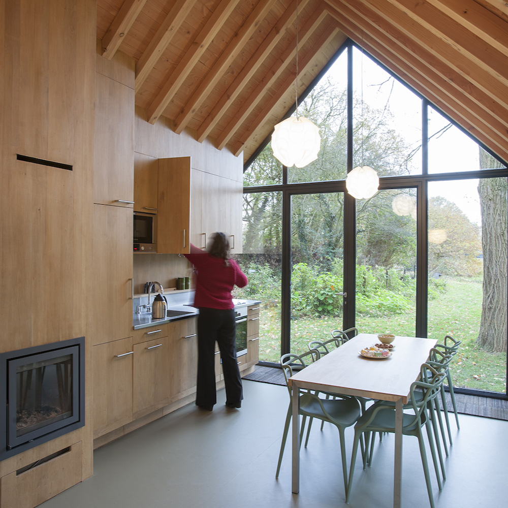 Dame in de keuken van een design vakantiehuis met grote glazen gevel