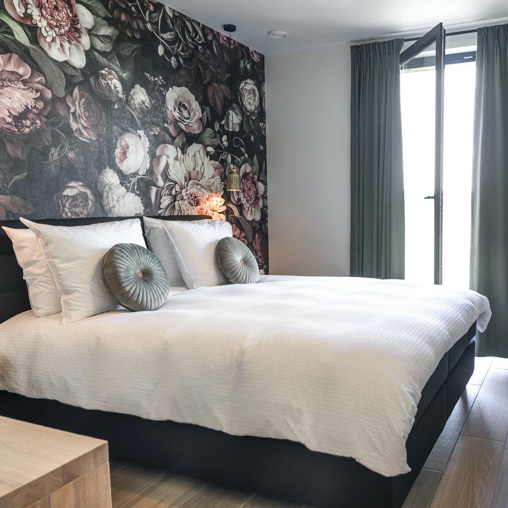 Bloemenbehang boven het comfortabele bed