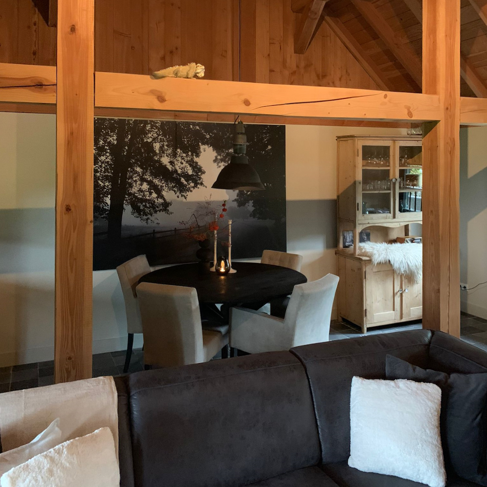 Doorkijk van zithoek naar eethoek in het vakantiehuis op de Veluwe