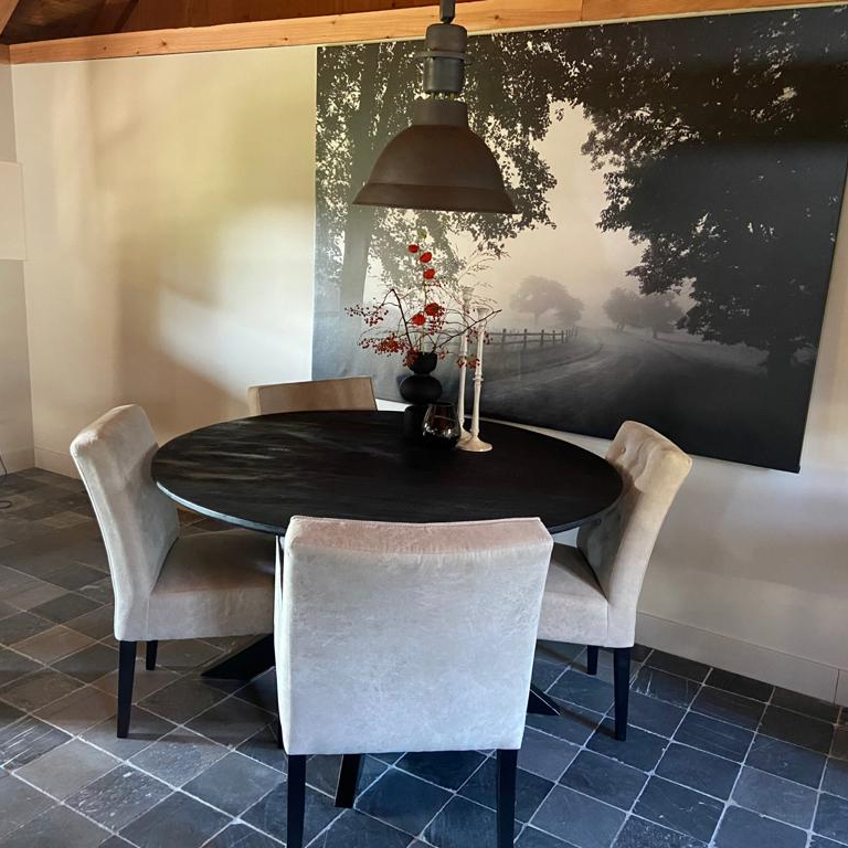 Ronde eettafel met grijze fauteuils in het vakantiehuis