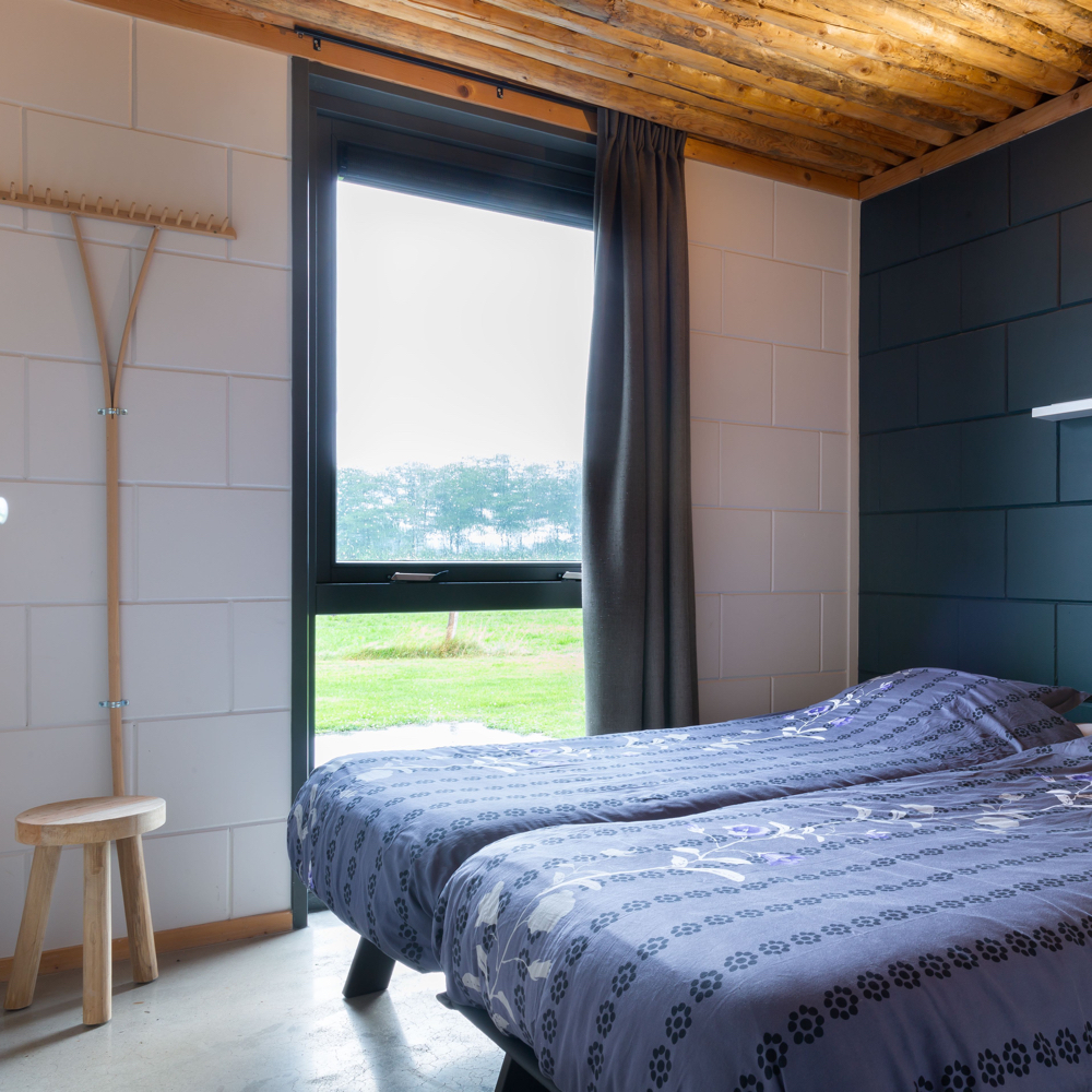 Slaapkamer met twee bedden met blauwe beddengoed