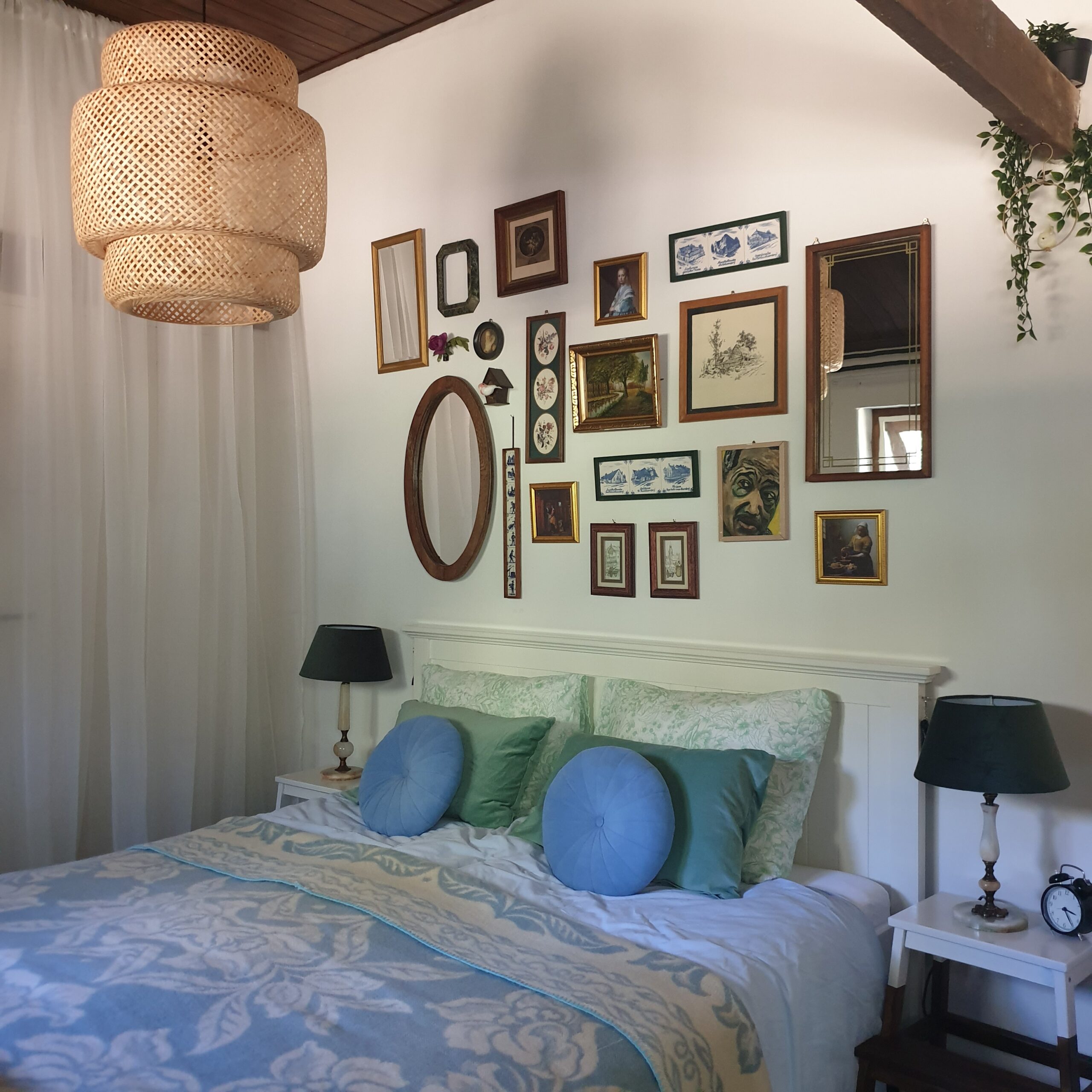 tweepersoons bed met een verzameling fotolijstjes erboven