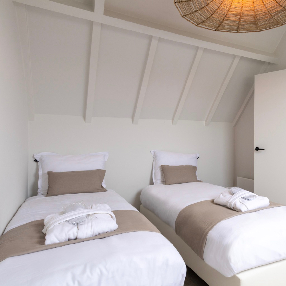 Slaapkamer met twee losse boxspringbedden in het vakantiehuis in Zeeland