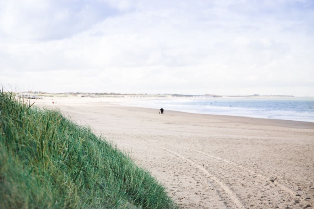 Verlaten strand in Zeeland met slechts twee wandelaars