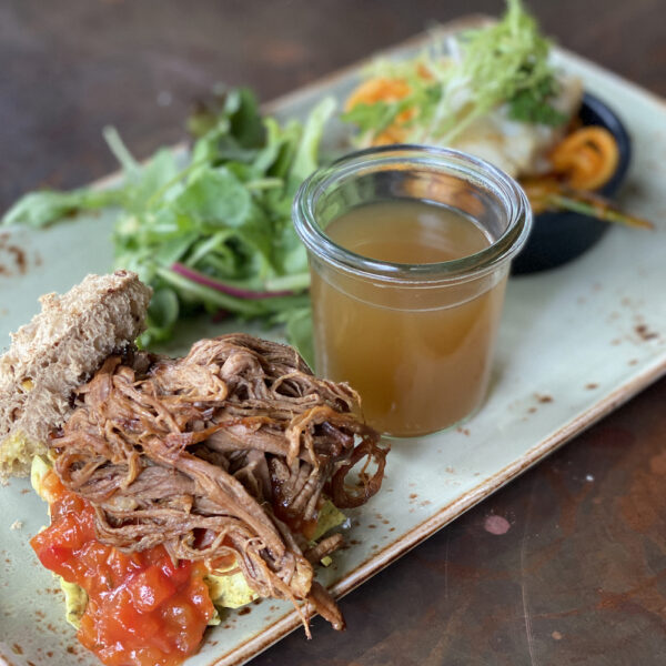 Bord met soepje, broodje pulled pork en salade