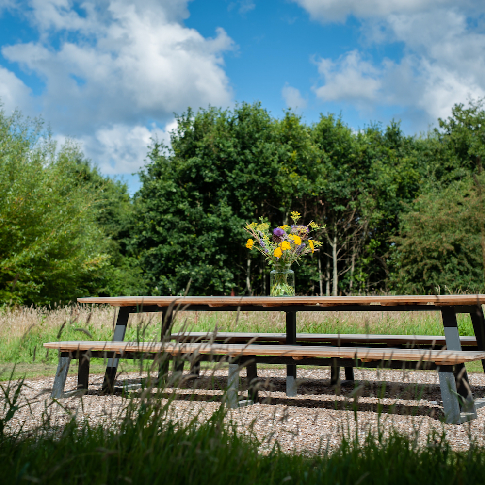Lange picknicktafel met veldboeket