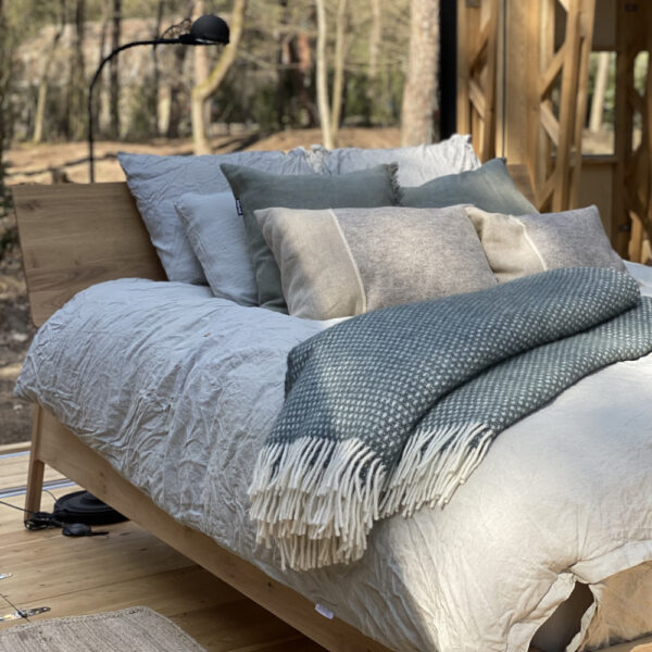 Tweepersoons bed met linnen beddengoed en warme sprei