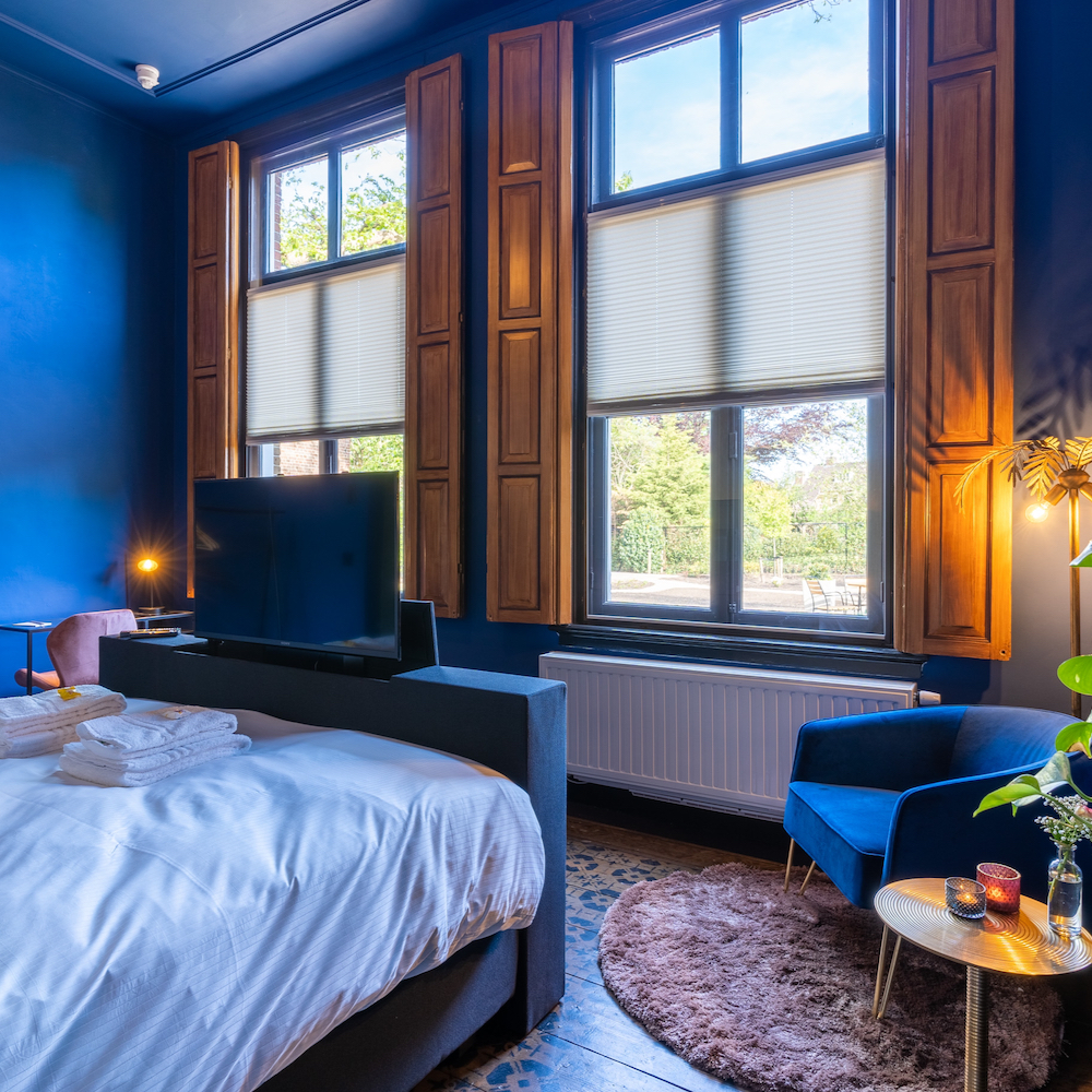 Comfortabel bed met televisie in een hotelkamer in Noord-Brabant
