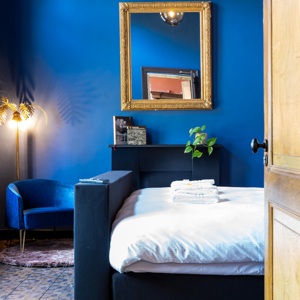 Sfeervolle hotelkamer met kleurrijke blauwe muur in Noord-Brabant