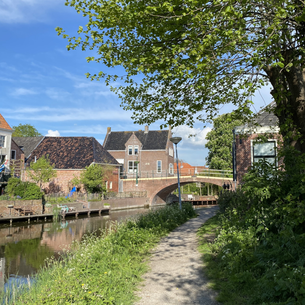 Wandelen over de kronkelige weggetjes langs het water van Winsum