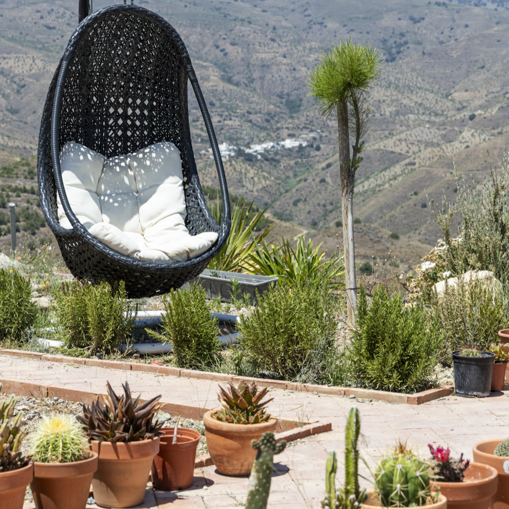 Zitje buiten tussen de planten en cactussen bij je villa in Spanje
