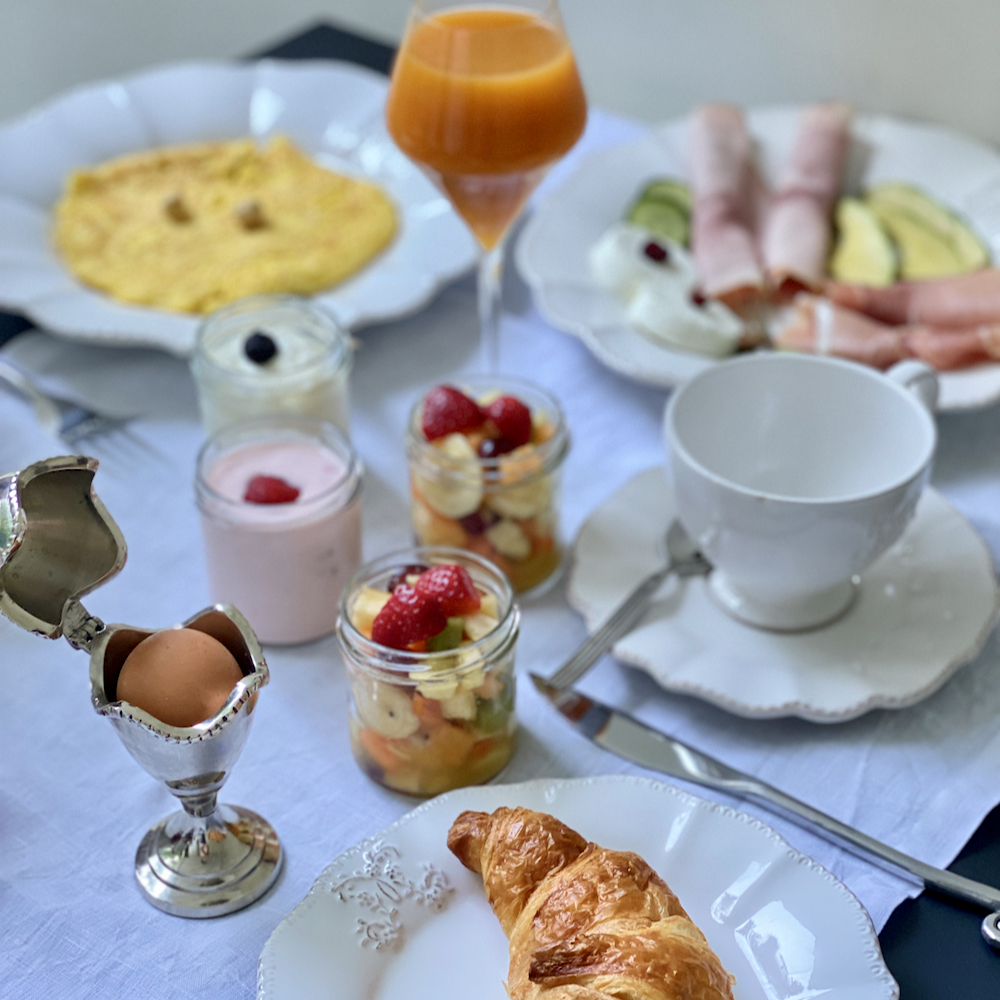 Ontbijt met eitje, croissant, sapje en vers fruit
