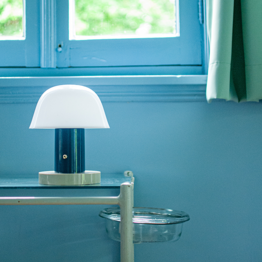 Lampje met witte kap in de blauwe slaapkamer