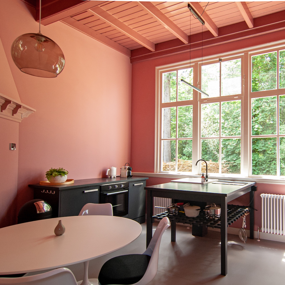 Roze keukenkamer met zwarte keuken