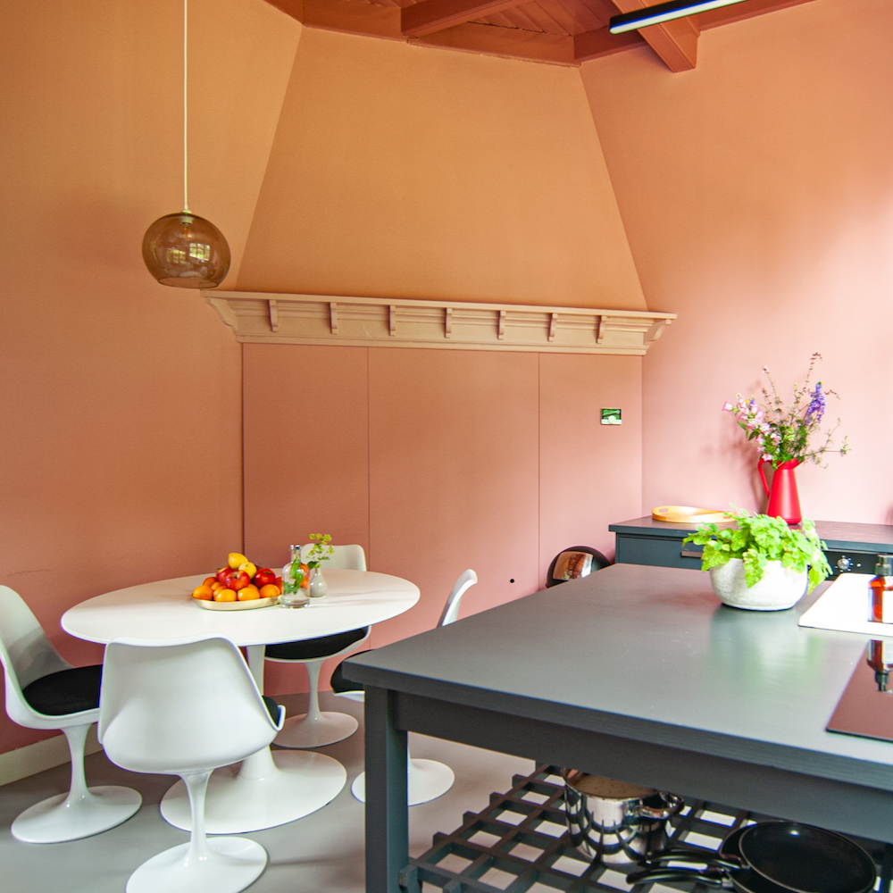 Roze keuken met witte eettafel in vakantiehuis weekendje weg