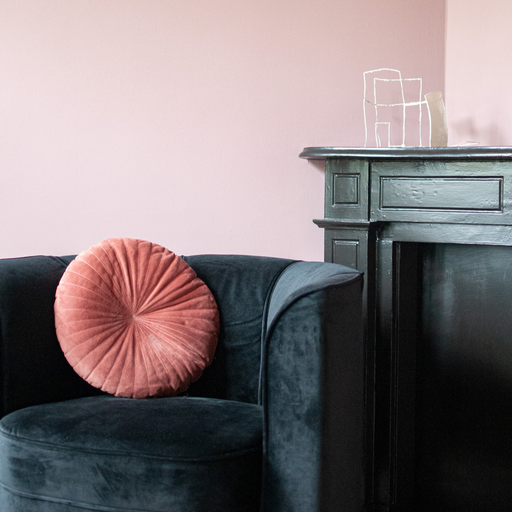 Zwarte bank met roze rond kussen