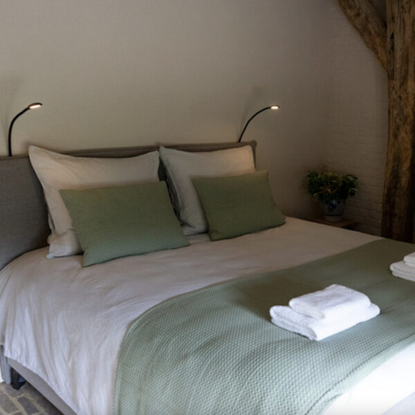 Opgemaakt bed met zacht bedlinnen