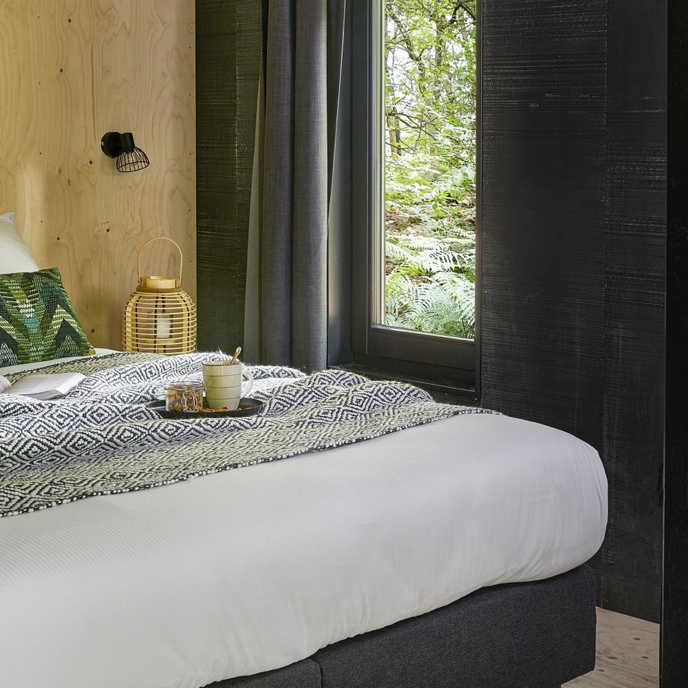 Slaapkamer met uitzicht op de natuur in een cabin in Gelderland