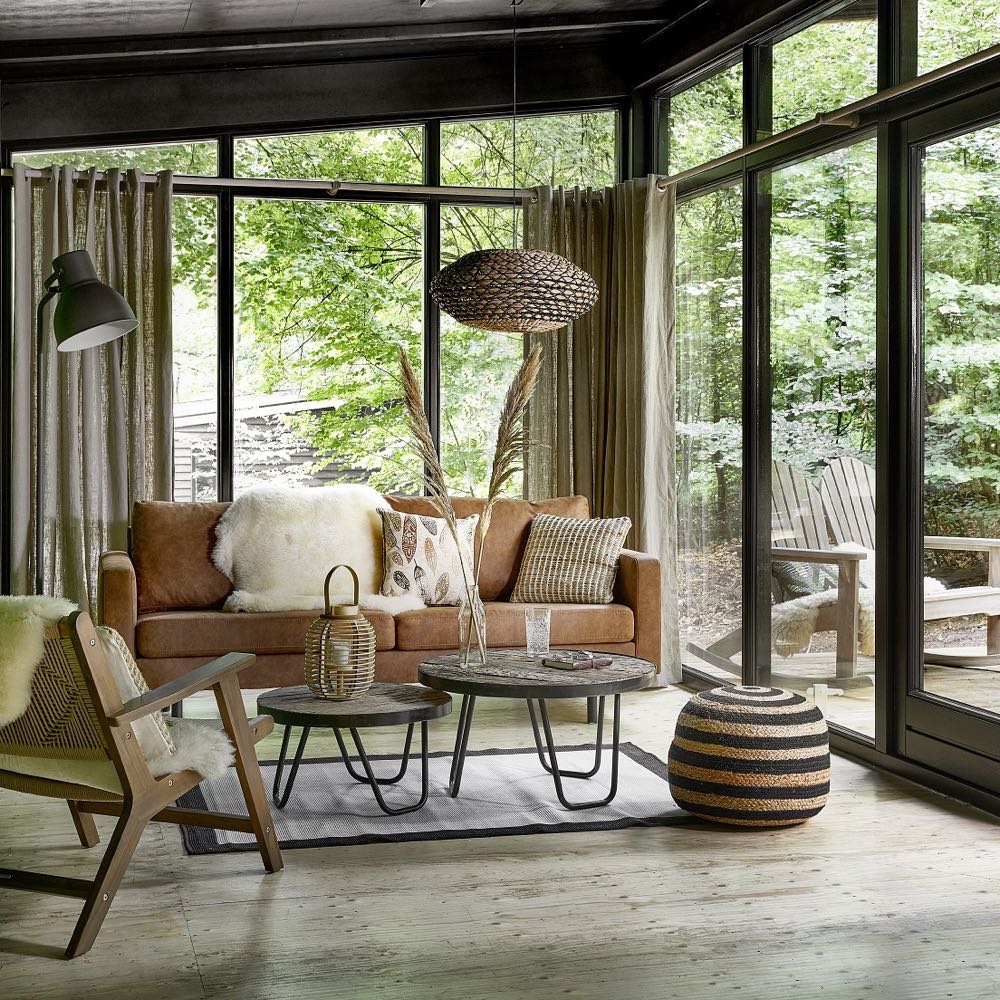 Sfeervolle zithoek met comfortabele bank in een cabin in Beekhuizen