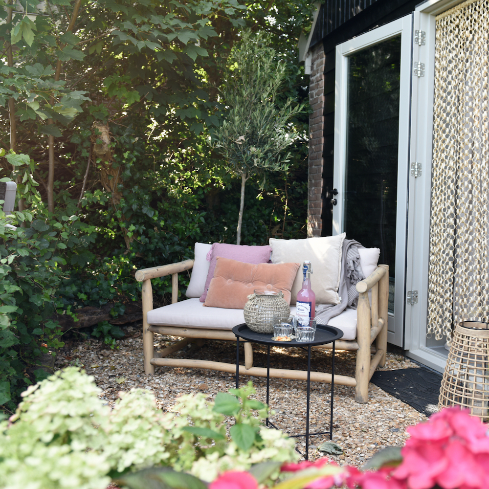 Tuinbankje met gekleurde kussens