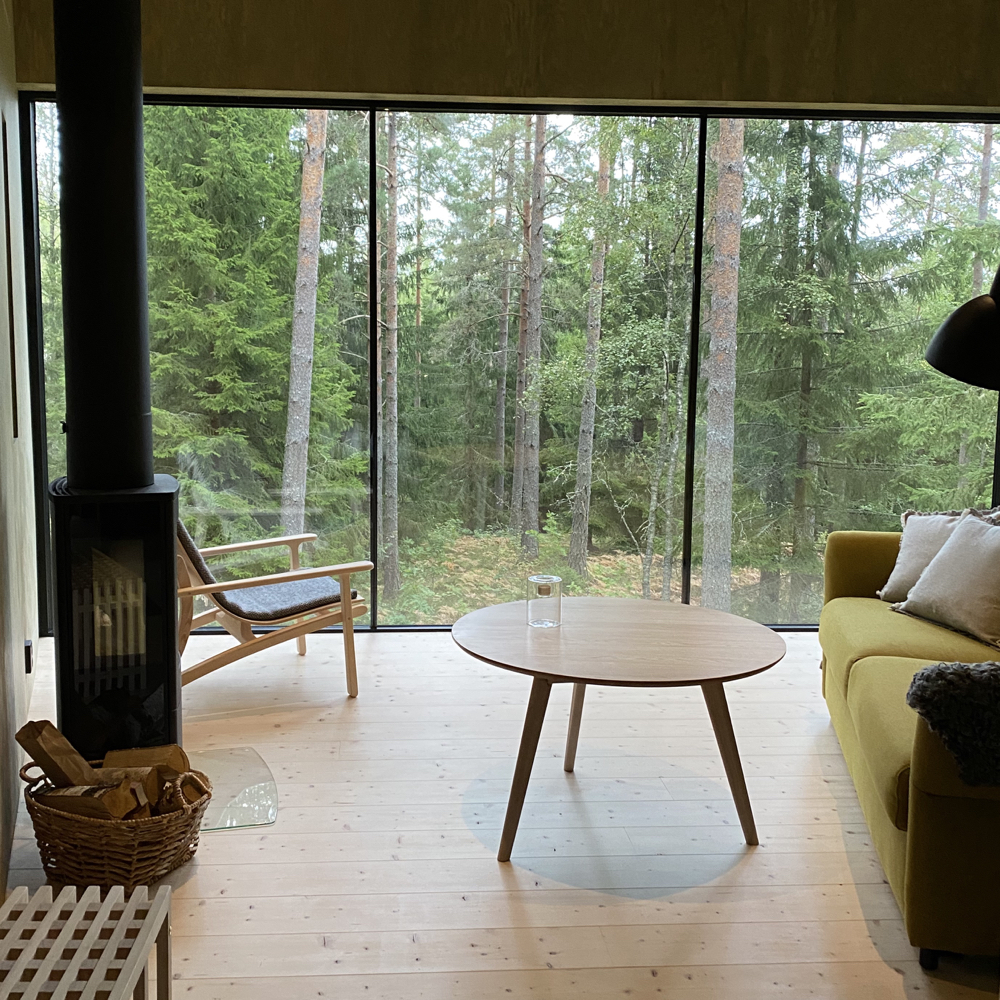 Sfeervolle woonkamer met houtkachel in een boomhut in Zweden