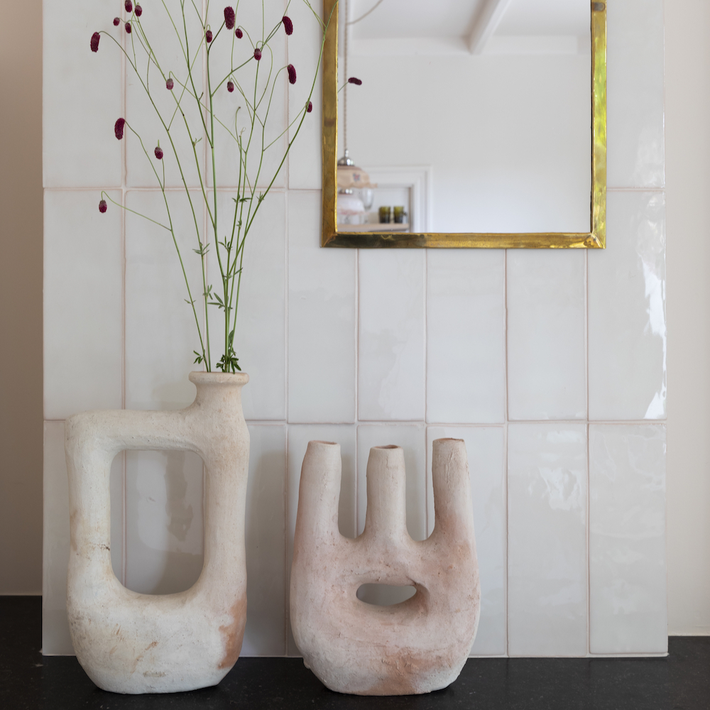 Vaasjes en een spiegel aan de wand