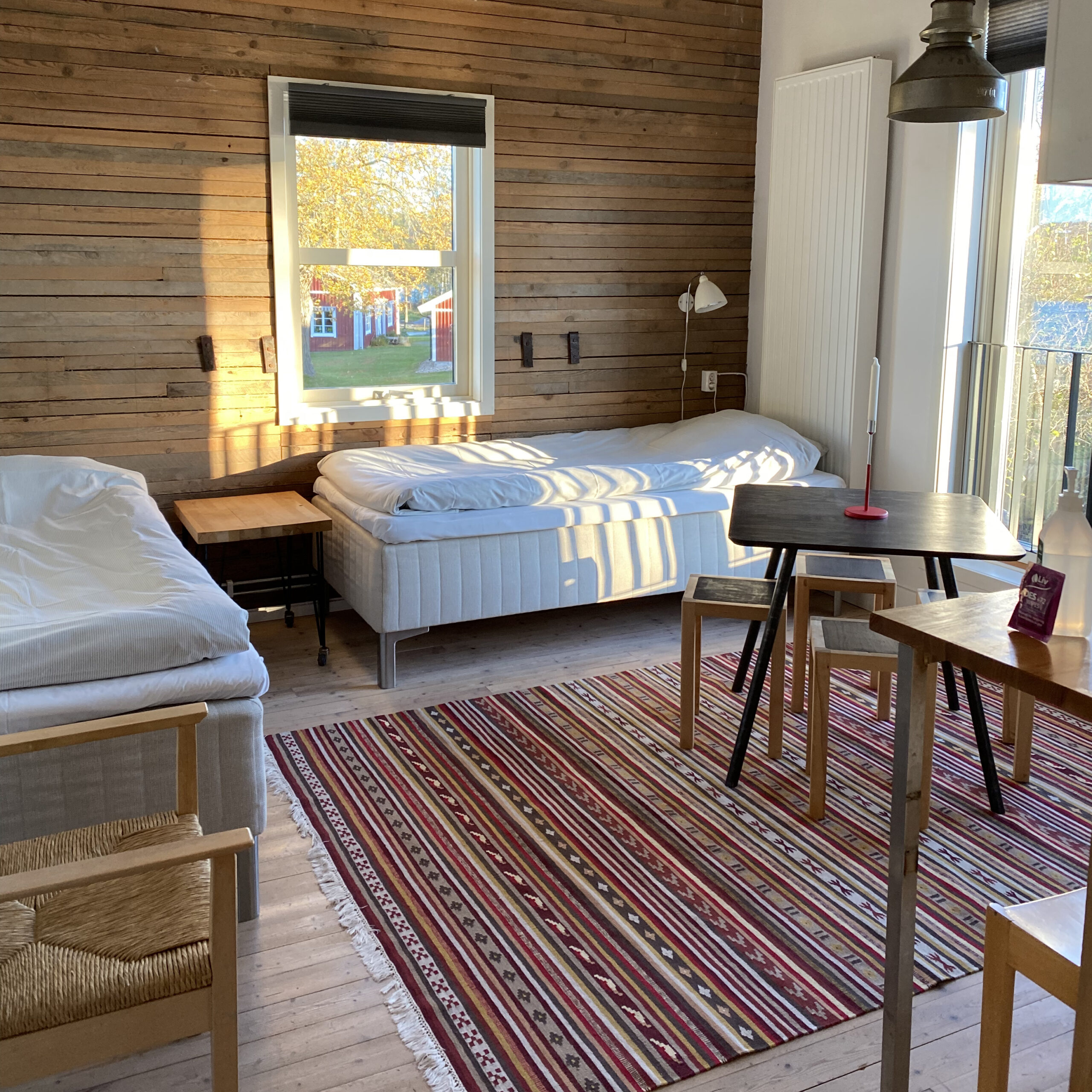 Twee bedden in het appartement met een eettafel in het midden.