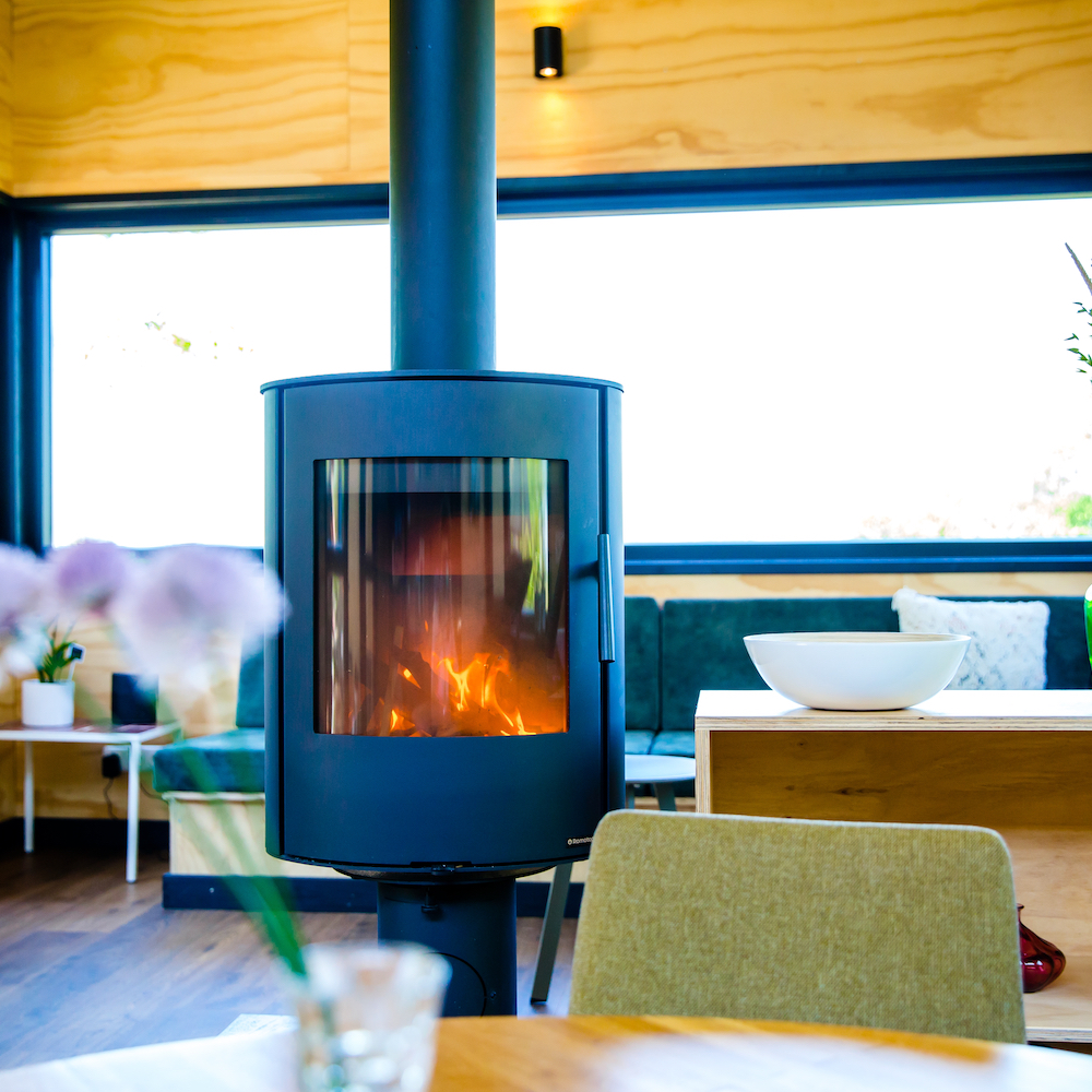 Brandende halfronde houtkachel in een van de vakantiehuisjes in Friesland.