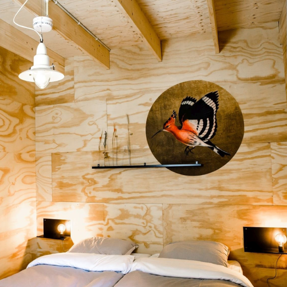 Slaapkamer met rond schilderij met een vogel erop.