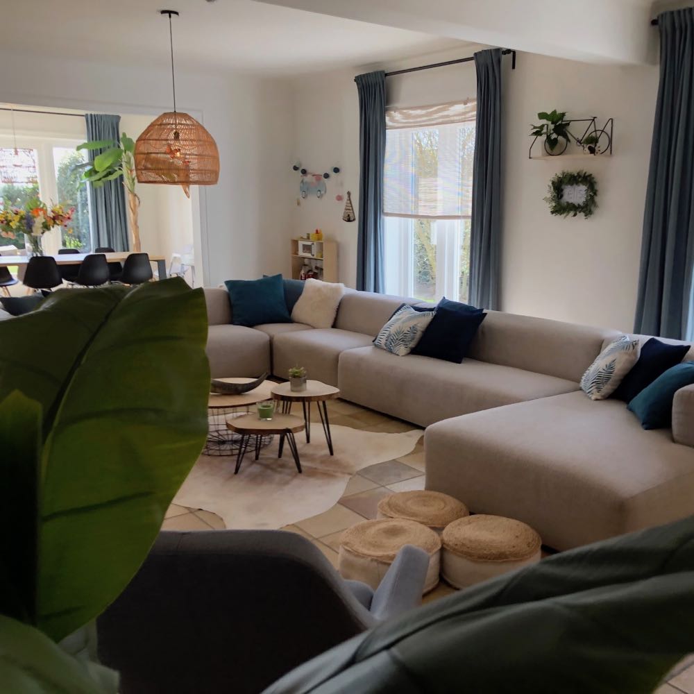 Sfeervolle woonkamer met enorme loungebank in een vakantiehuis in België