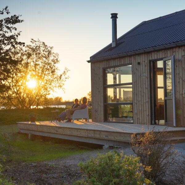 Vakantiehuisje aan het water bij zonsondergang