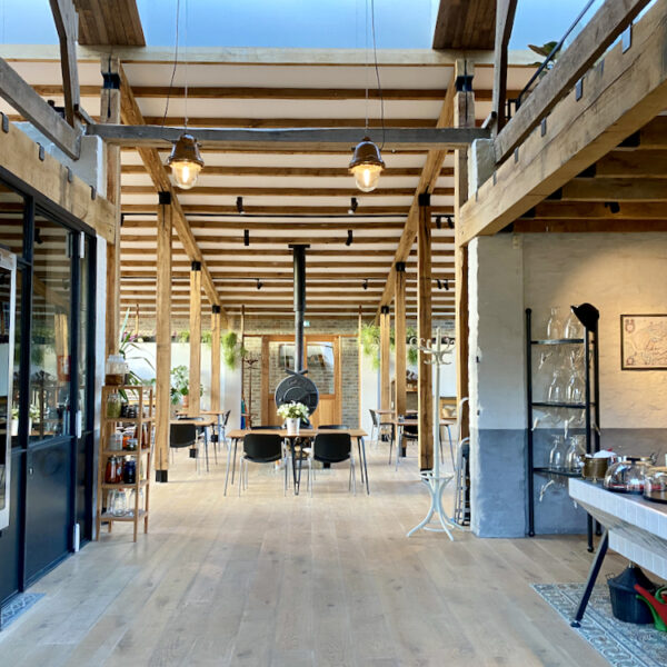 Restaurant met hoge plafonds, een stoere houtkachel