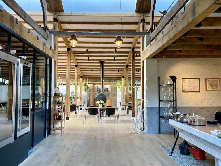 Restaurant met hoge plafonds, een stoere houtkachel