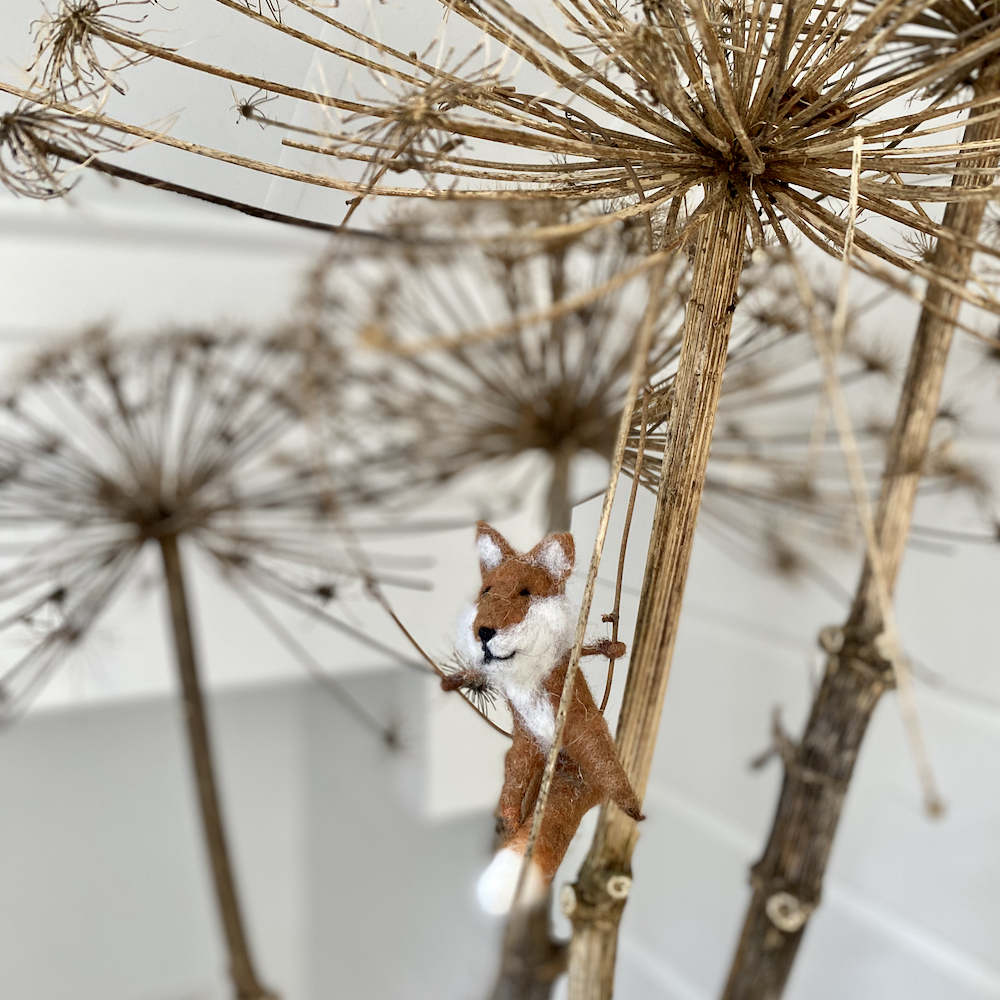 Vosje van vilt in een tak