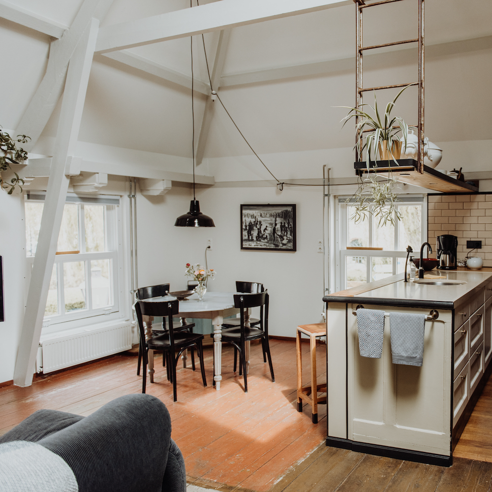 Ronde witte eettafel en zwarte stoelen