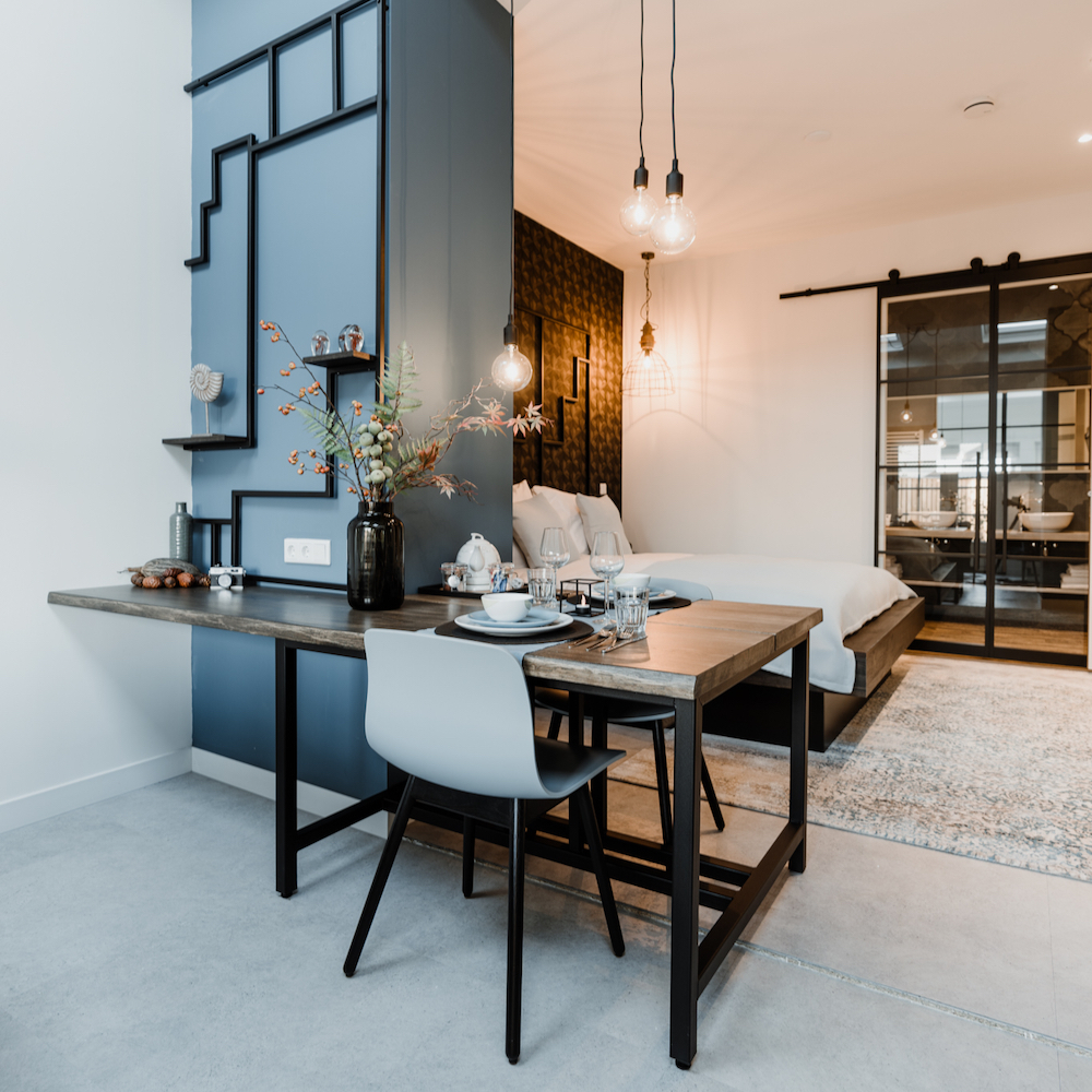 Eethoek in hotelkamer en badkamer met stalen deuren