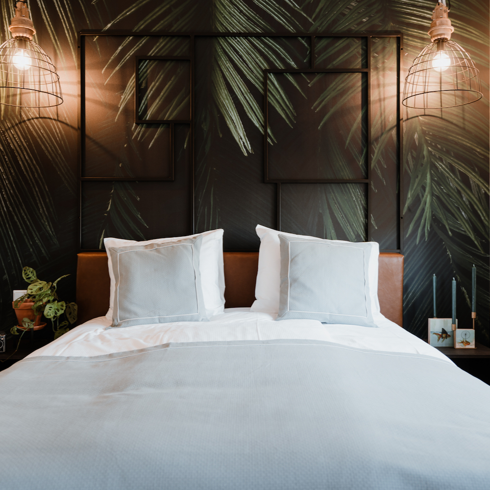 Tropisch behang achter het bedhoofd
