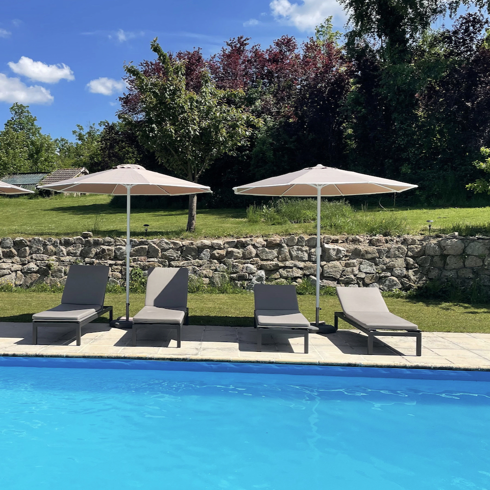 Zwembad met ligstoelen en parasols