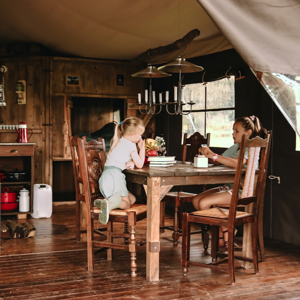 Kinderen aan tafel in een safaritent