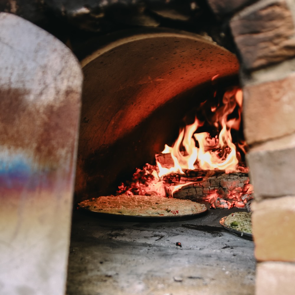Pizza in de houtgestookte oven