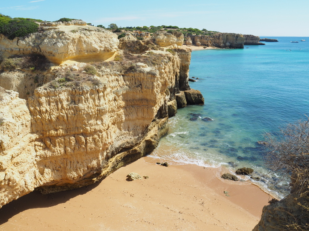 Eine der felsigen Buchten mit goldenem Strand und klarem, blauem Meer