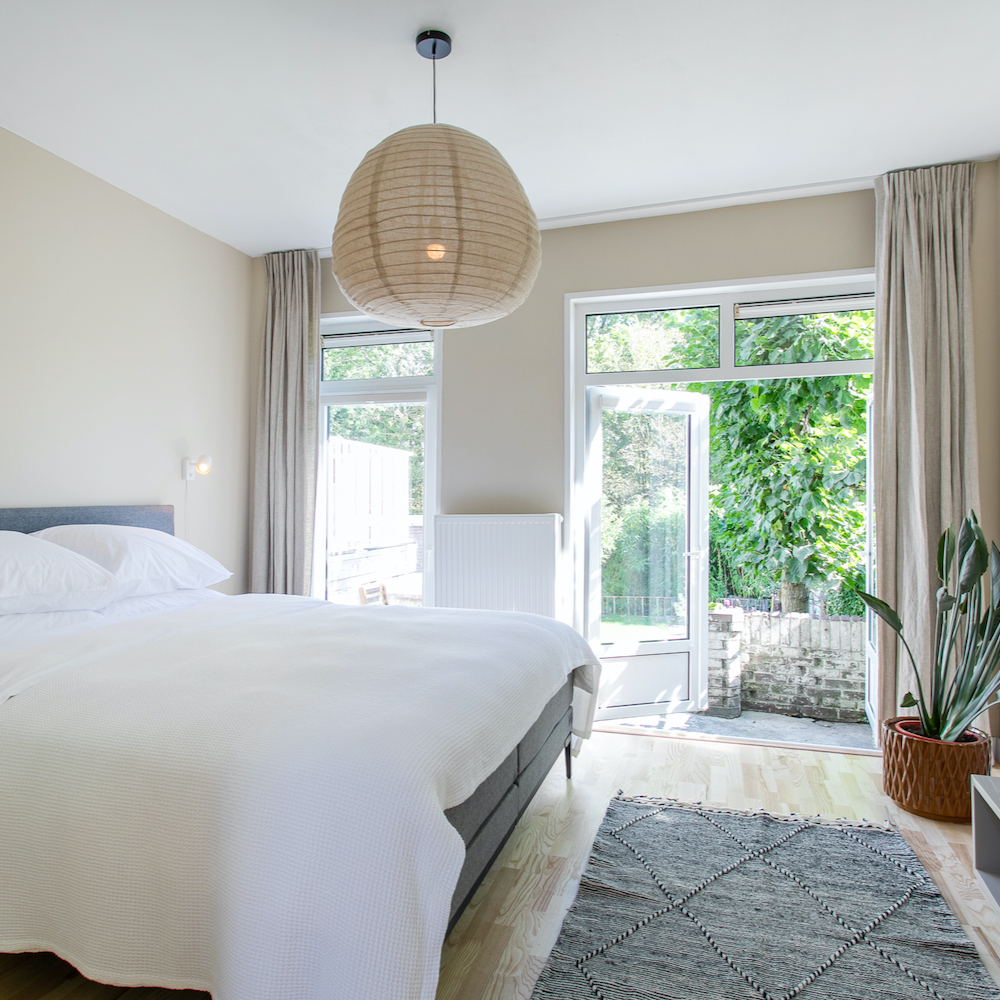 Schlafzimmer mit französischen Fenstern in einem B&B in Amsterdam