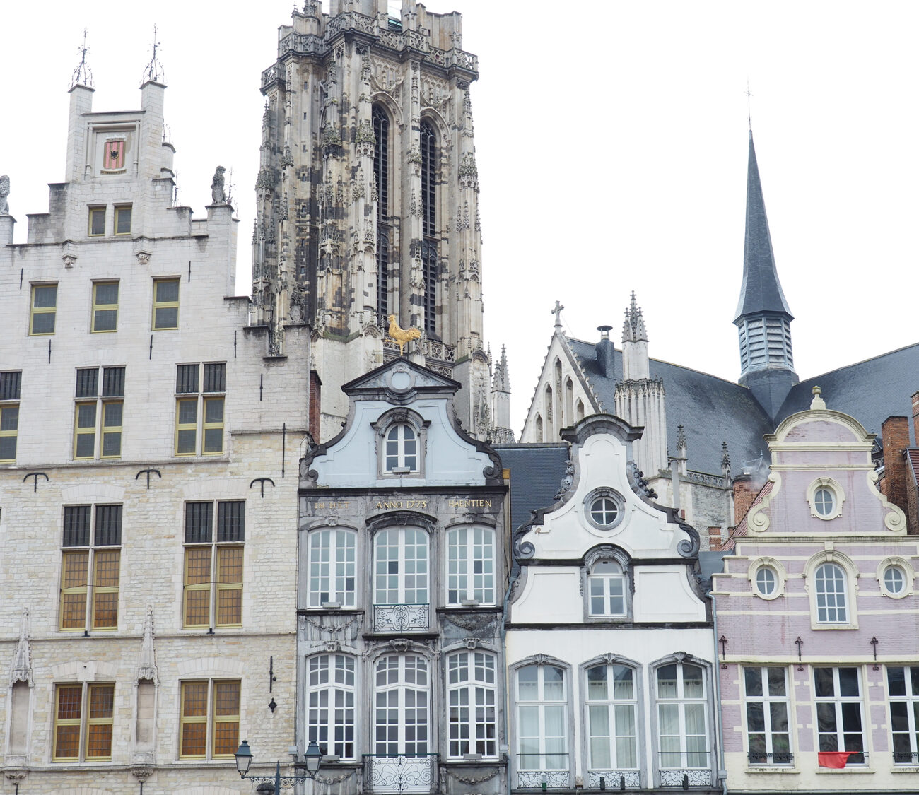 Historische Fassaden auf dem Marktplatz in Mechelen, mit dem großen Kirchturm im Hintergrund