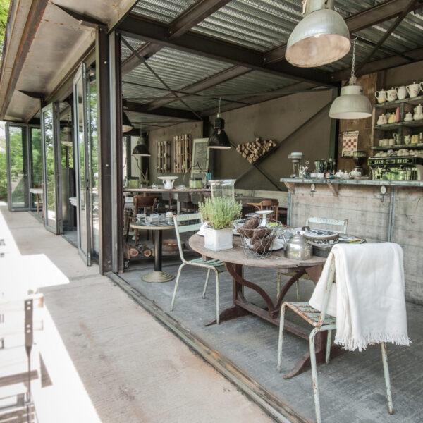 Ein Tisch und Stühle im Brocante-Stil mit offener Fassade