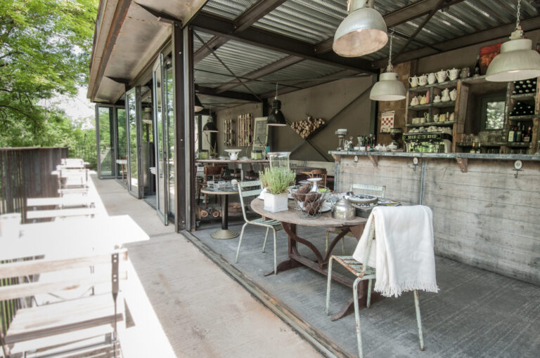Ein Tisch und Stühle im Brocante-Stil mit offener Fassade