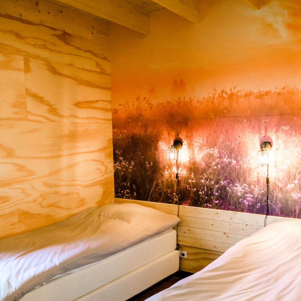 Schlafzimmer mit zwei Einzelbetten, in einer der Wasserhütten in Friesland.