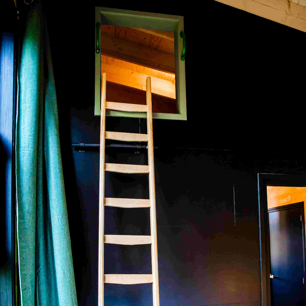 Holztreppe zu einem Schlafbereich im Dachfirst des Ferienhauses.