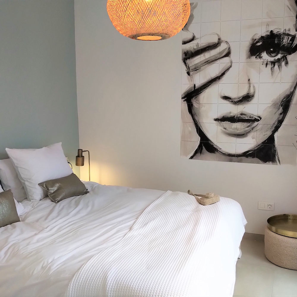 Schlafzimmer mit grüner Wand und großem IXXI-Poster in schwarz-weiß.
