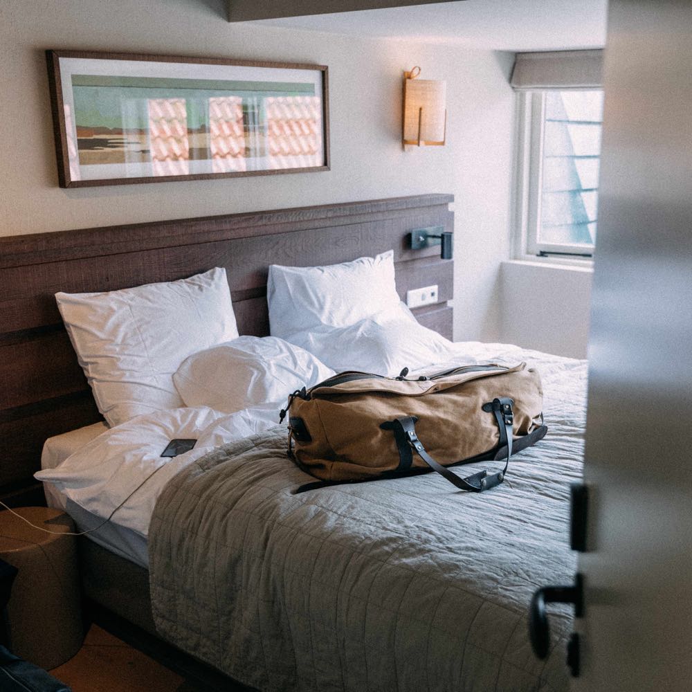 Schlafzimmer in der Lodge, mit Reisetasche auf dem Bett